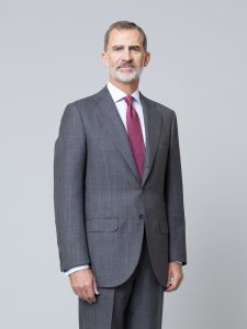 King Felipe stands in a suit facing the camera