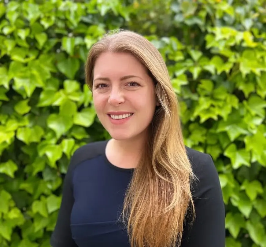 Kira Akka-Seidel Headshot, wearing a navy blue long-sleeve crewneck shirt.