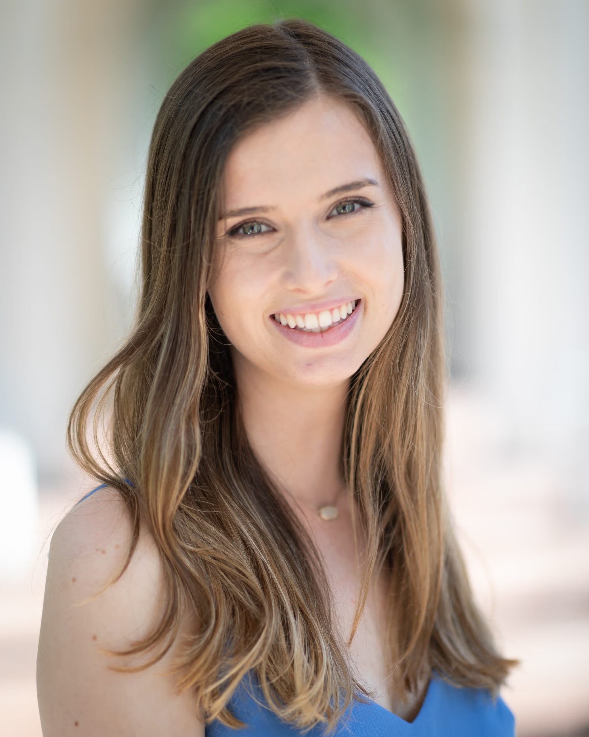 Logan Petkosek Headshot, wearing a royal blue sleeveless top.