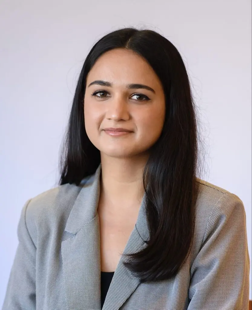 Misbah N. Headshot, wearing a light gray blazer and black top.