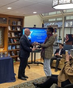 Camille Grayson accepts a staff award from SFS Dean Joel Hellman