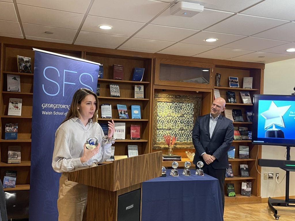 Patty Ritter speaks at the podium in McGhee Library, while SFS Dean Joel Hellman listens to her right.