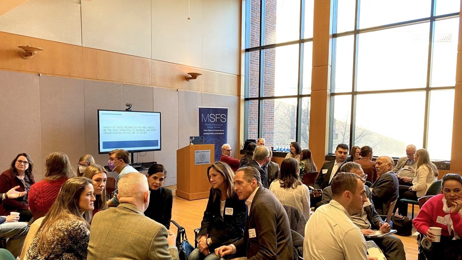 Casual group discussions between men and women attending 100 year daytime program.