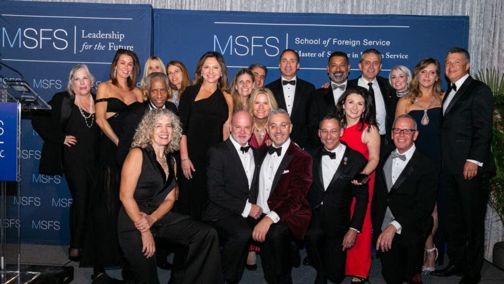 Large group of gala attendees in formalwear, gathered together.