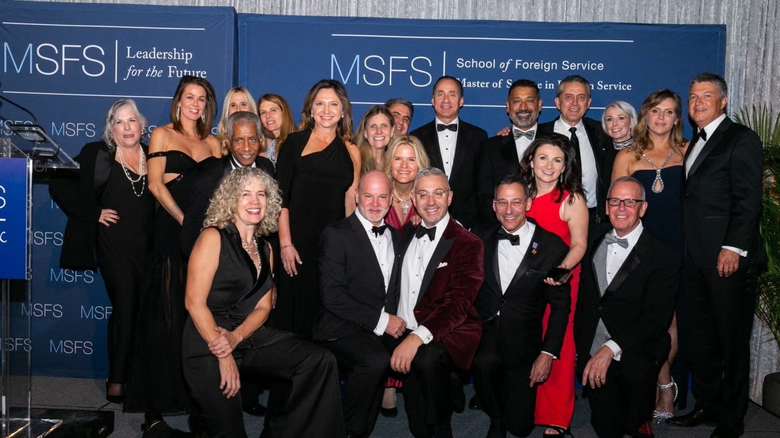 Large group of gala attendees in formalwear, gathered together.