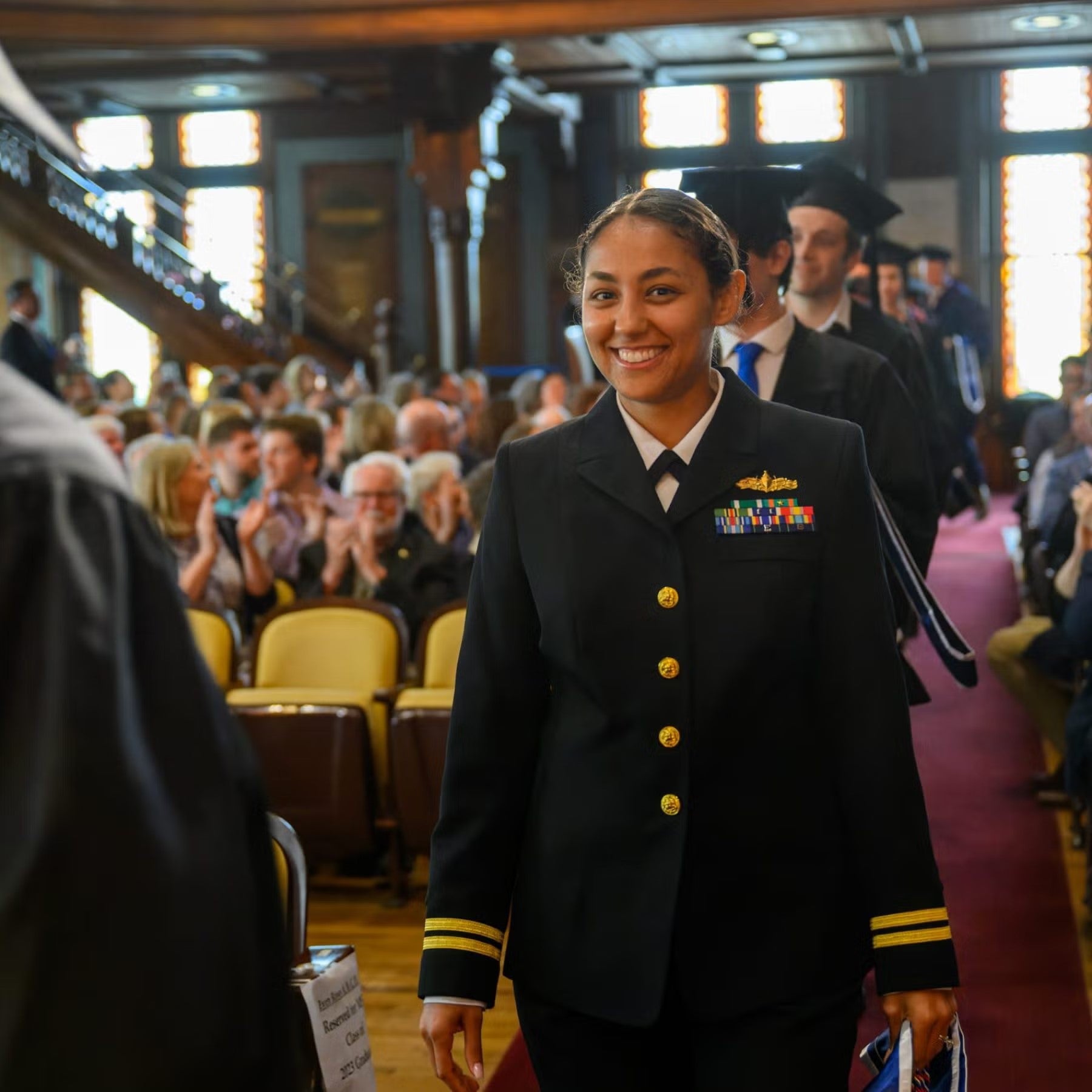 Jasmin Alsaied processing in full military dress towards platform during commencement, to receive her MSFS degree.