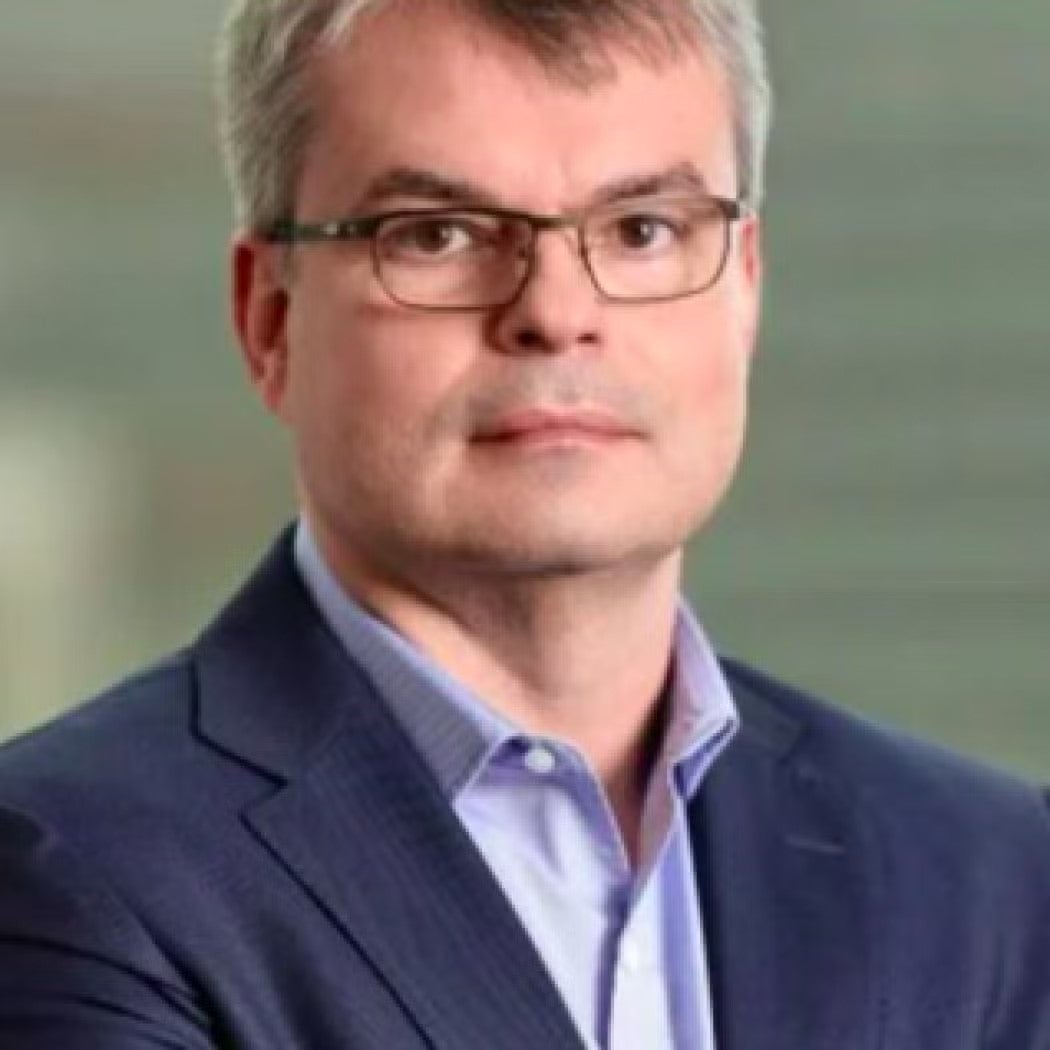 Tony Volpon Headshot in navy blue blazer and light blue shirt.