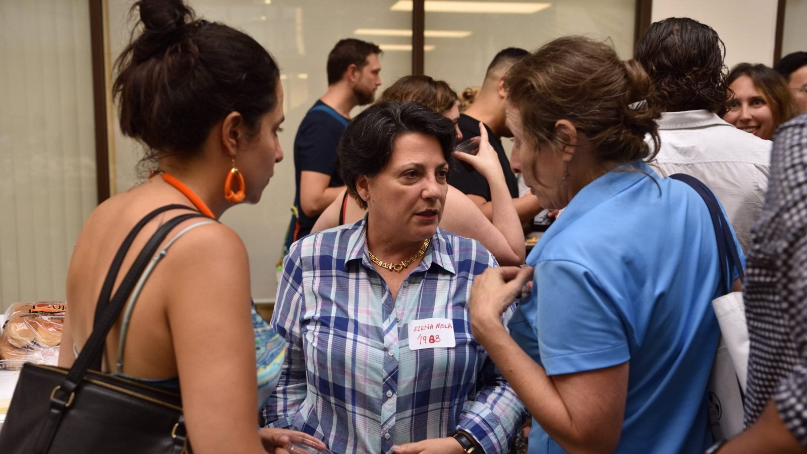 Three women talking at a reception.