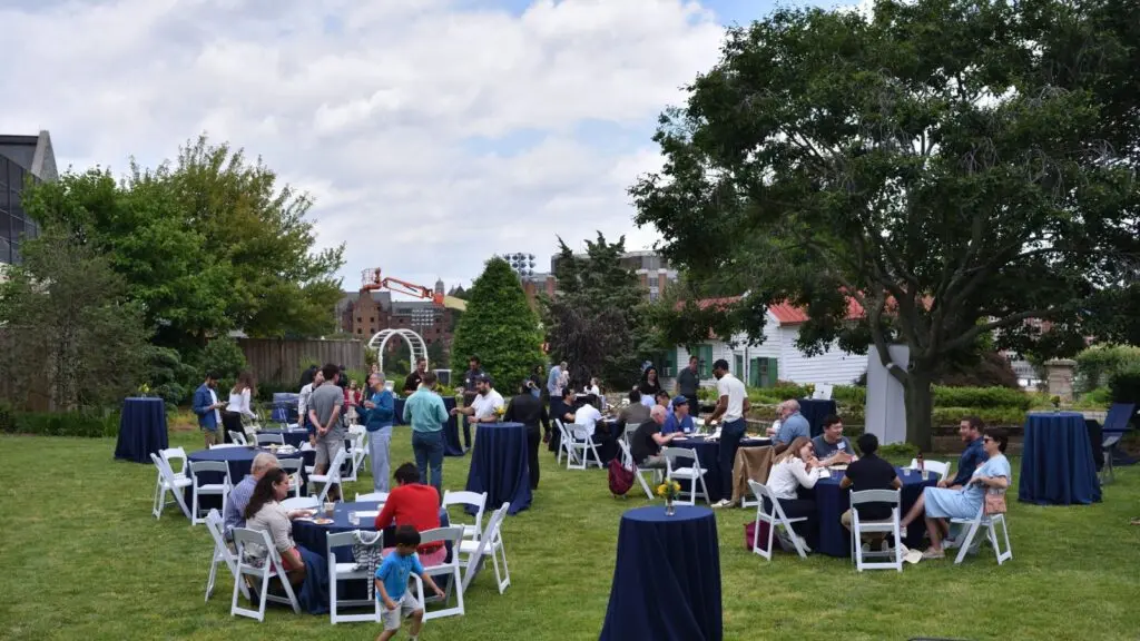 Several tables of people outside.