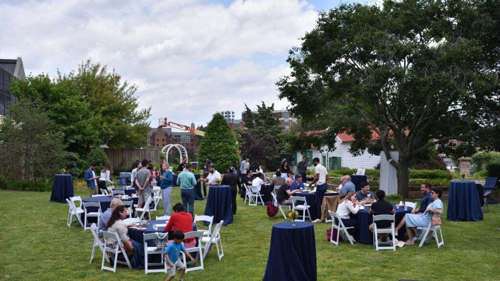Several tables of people outside.