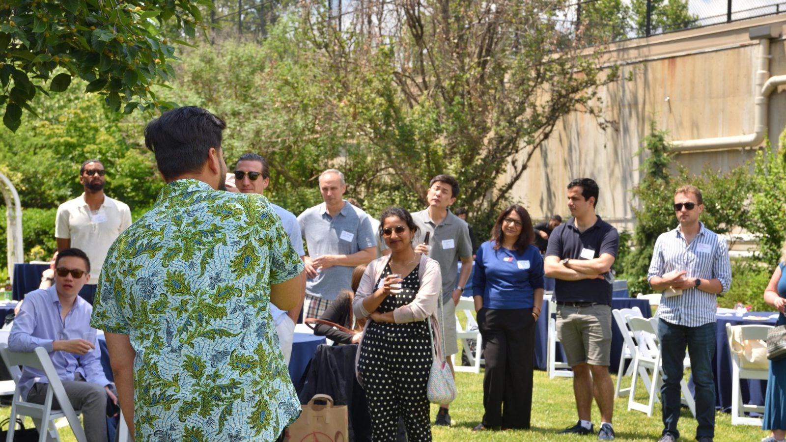 A group of people standing together outside and talking. 