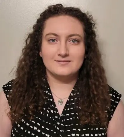 Catherine Hodgson headshot. She is wearing a sleeveless, black top with a small white pattern print.