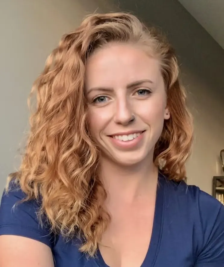 Clarissa Guglielmelli headshot, wearing navy blue v-neck top.