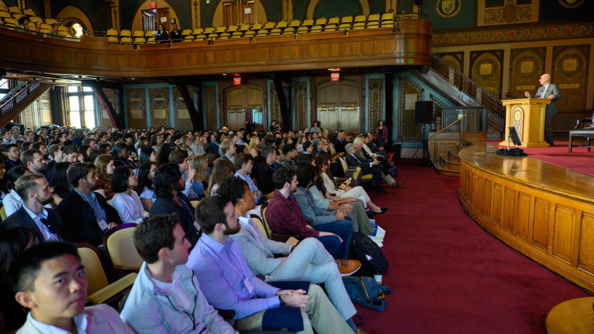 Dean Hellman speaks to an audience of new graduate students in Gaston Hall.