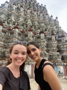 Valeria Torres Ruiz stands in front of a historical site in Thailand with another woman.