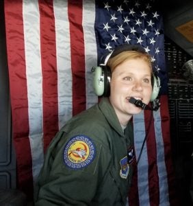 Chelsea Hollenback in her U.S. Air Force uniform in front of a U.S. flag.