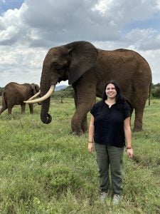 Ksenia Dubova standing in front of a large elephant.