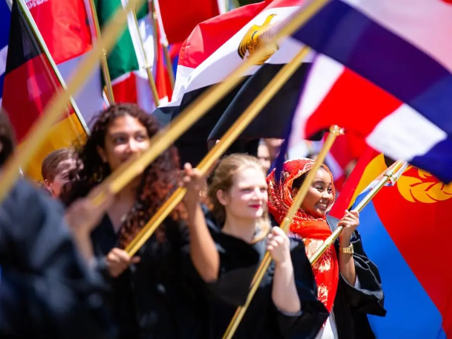 Students holding flags at convocation.
