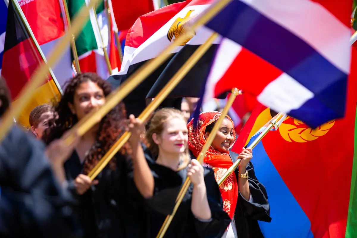 Students holding flags at convocation.