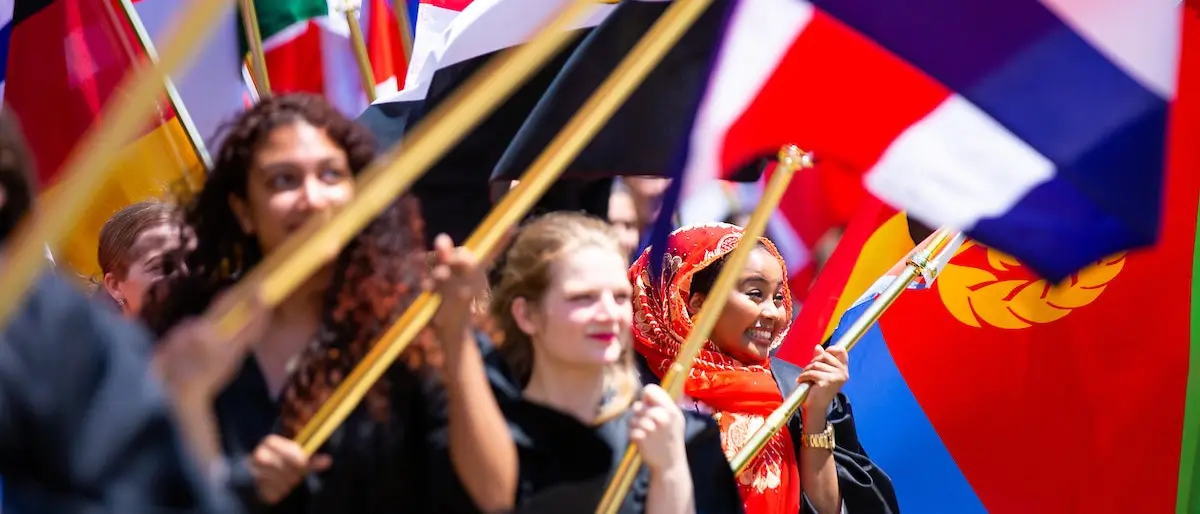 Students holding flags at convocation.