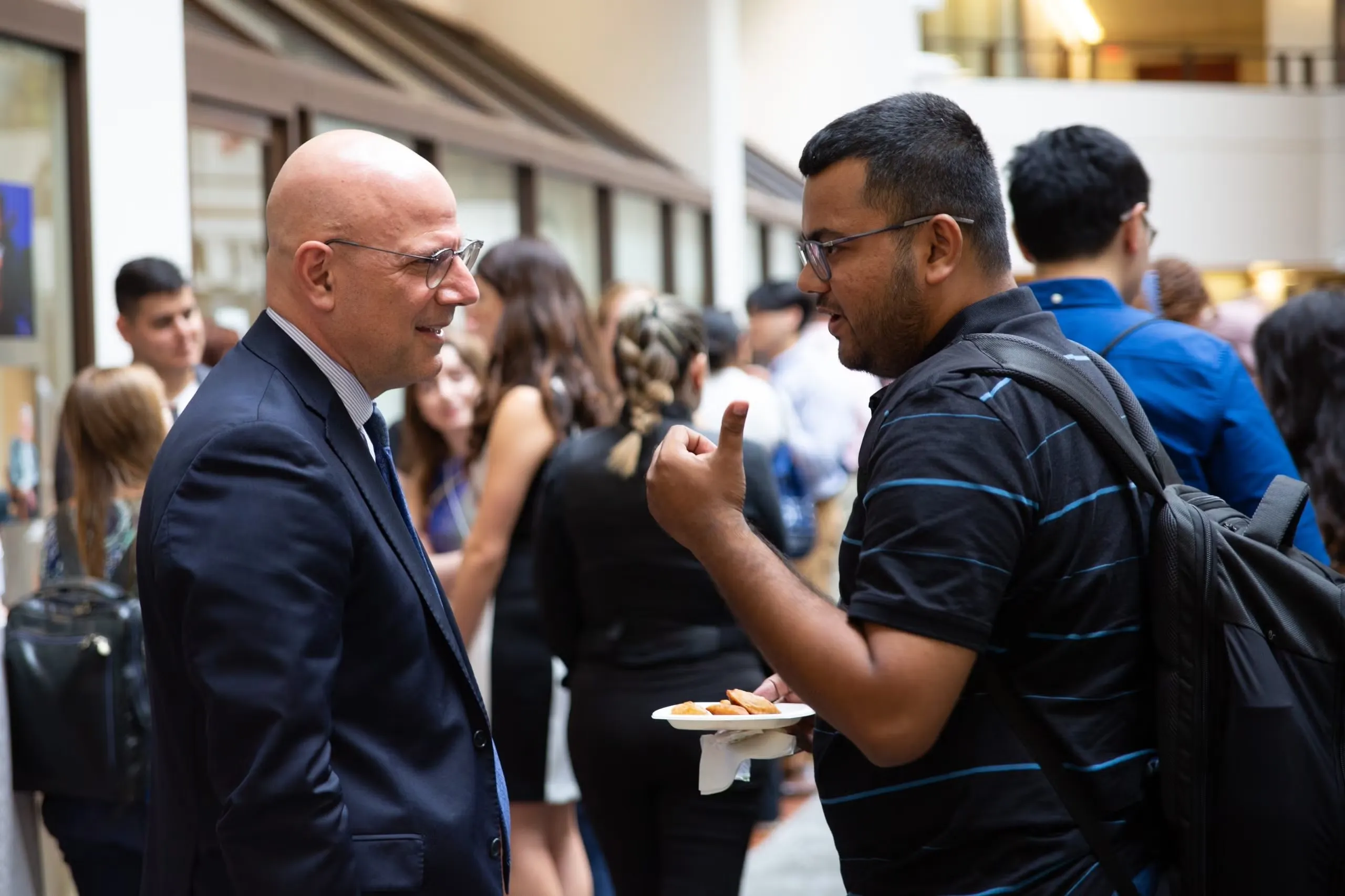 A student and a professor chatting at an event.
