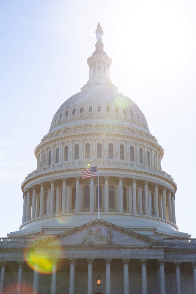 U.S. Capitol Hill building, U.S. flag in the sunshine