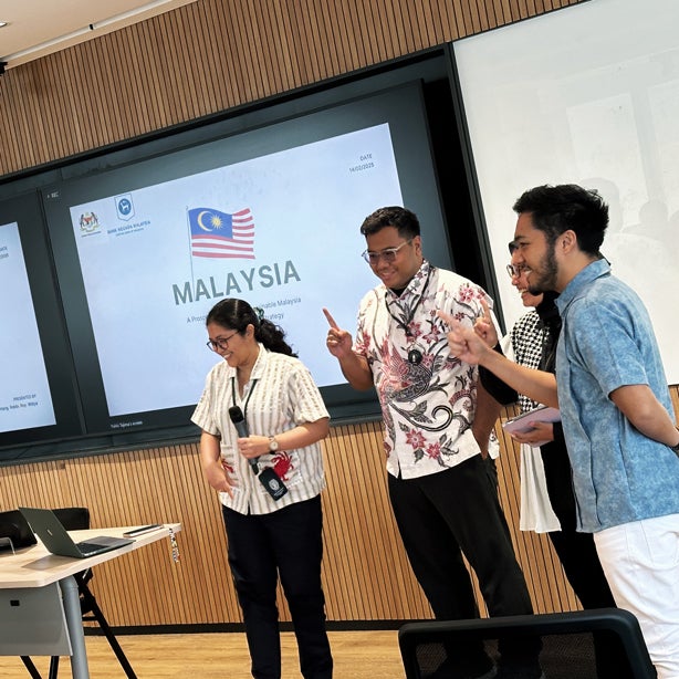 Students in Indonesia presenting in class, background slide is titled Malaysia