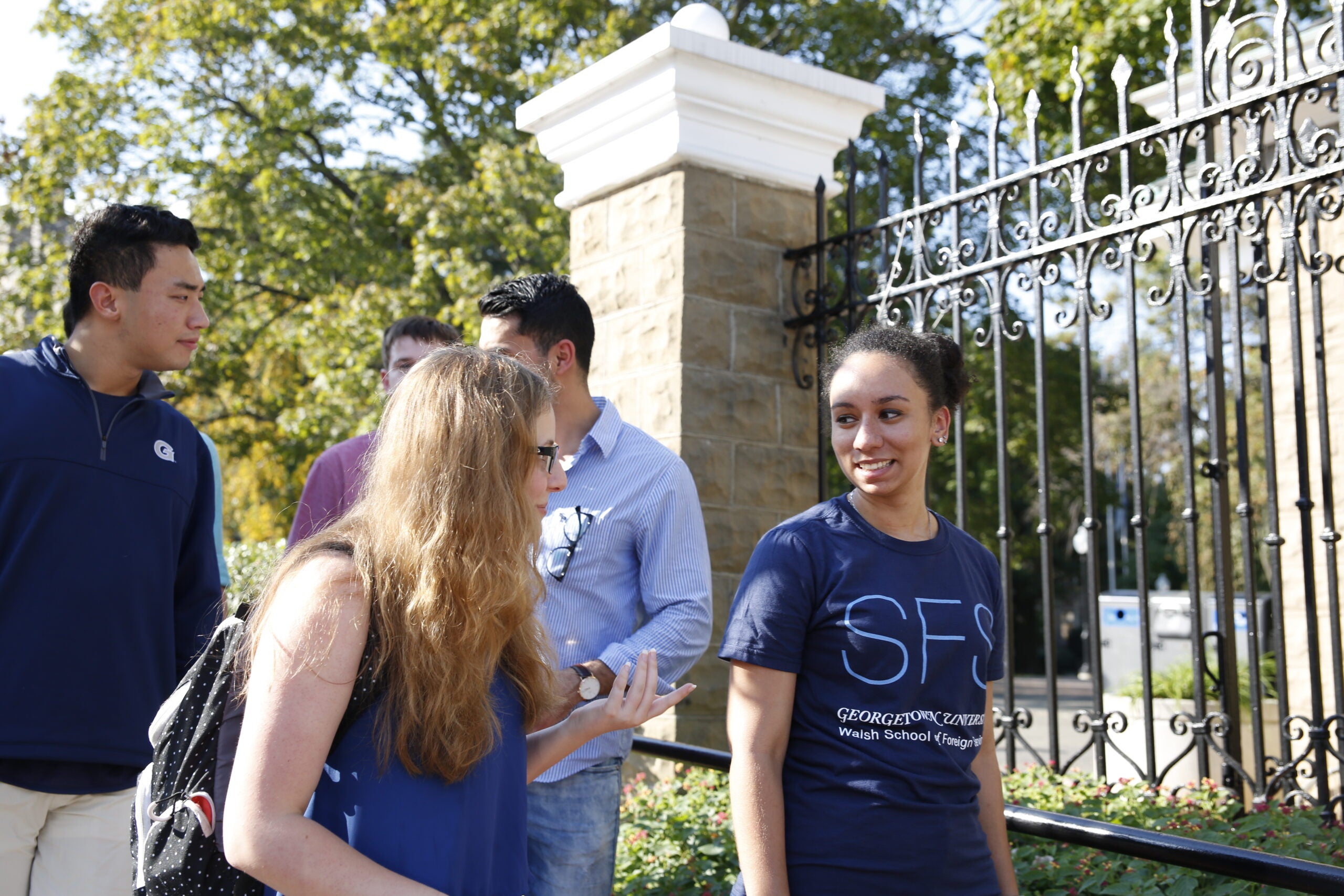 Students walking on campus and talking.