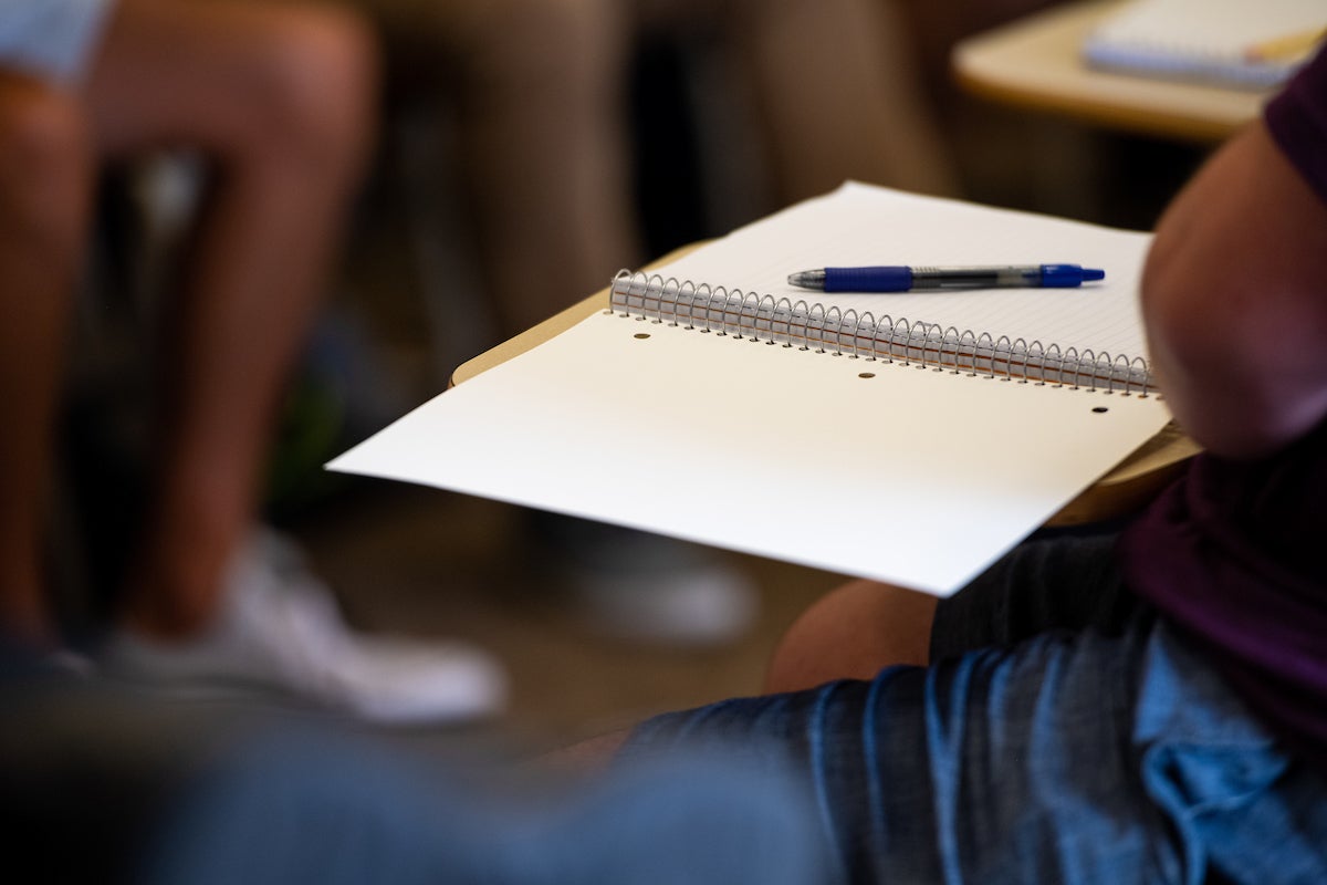 Blank open notebook in a classroom setting