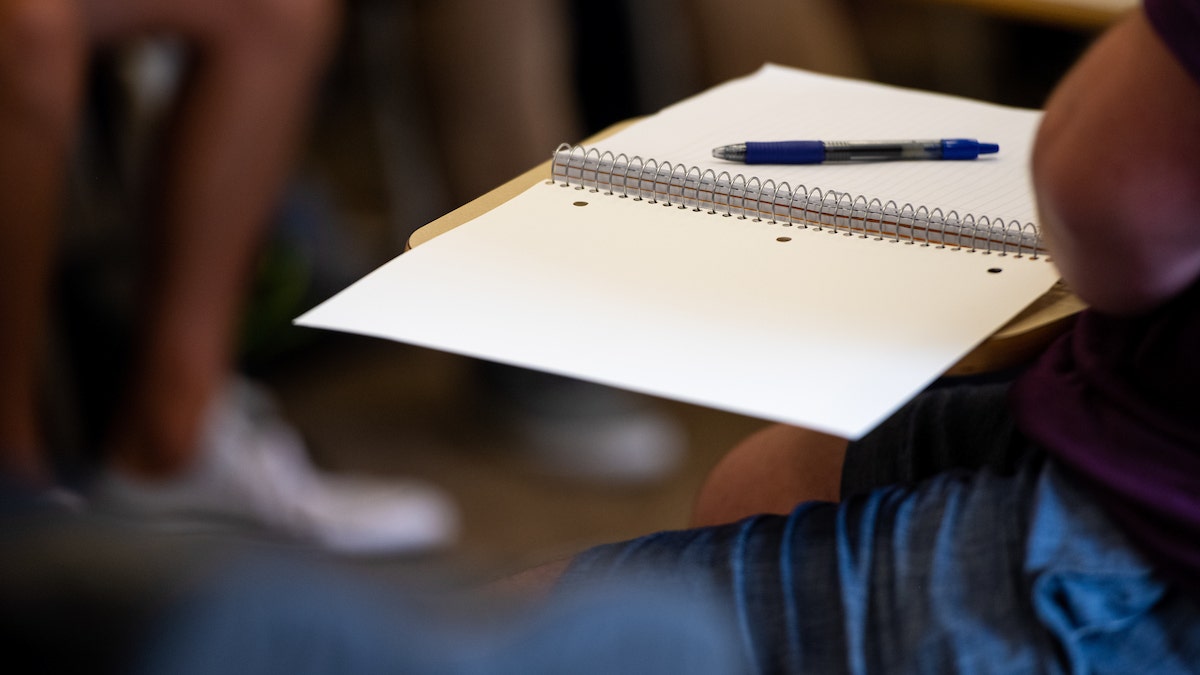 Blank open notebook in a classroom setting