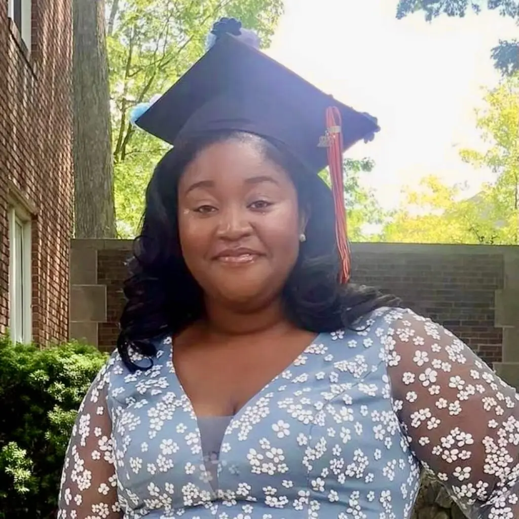 Aramide Apo-Oyin wearing a blue floral blouse and a graduation cap.