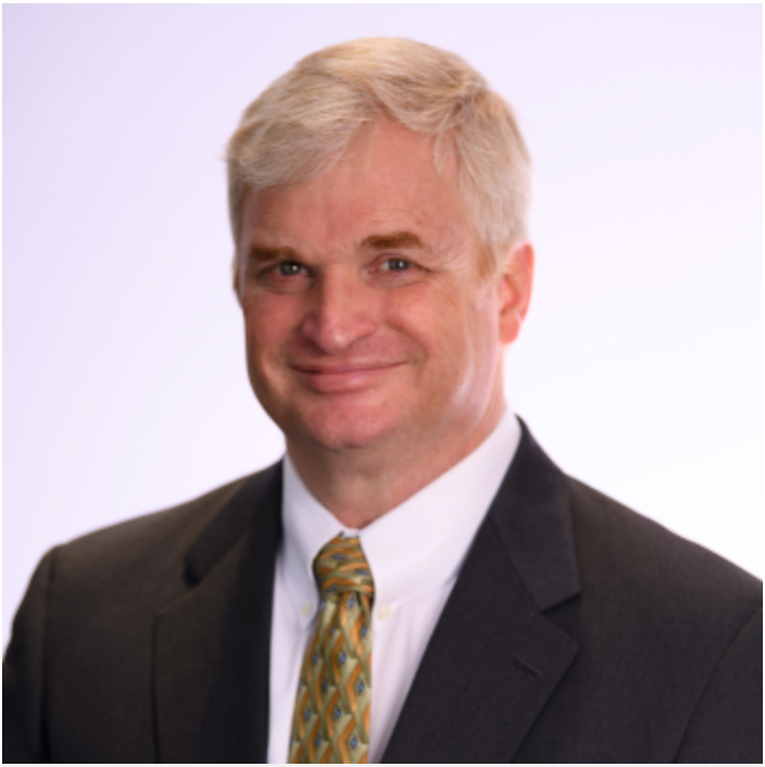 Prof. Shambaugh smiling and wearing a suit with a green and yellow tie.