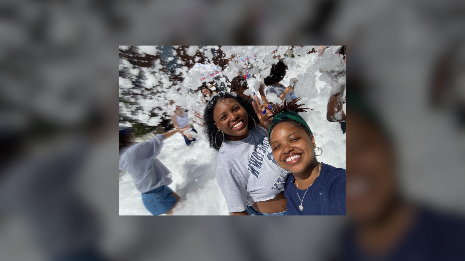 Two individuals with joyful expressions participating in a snowball fight.
