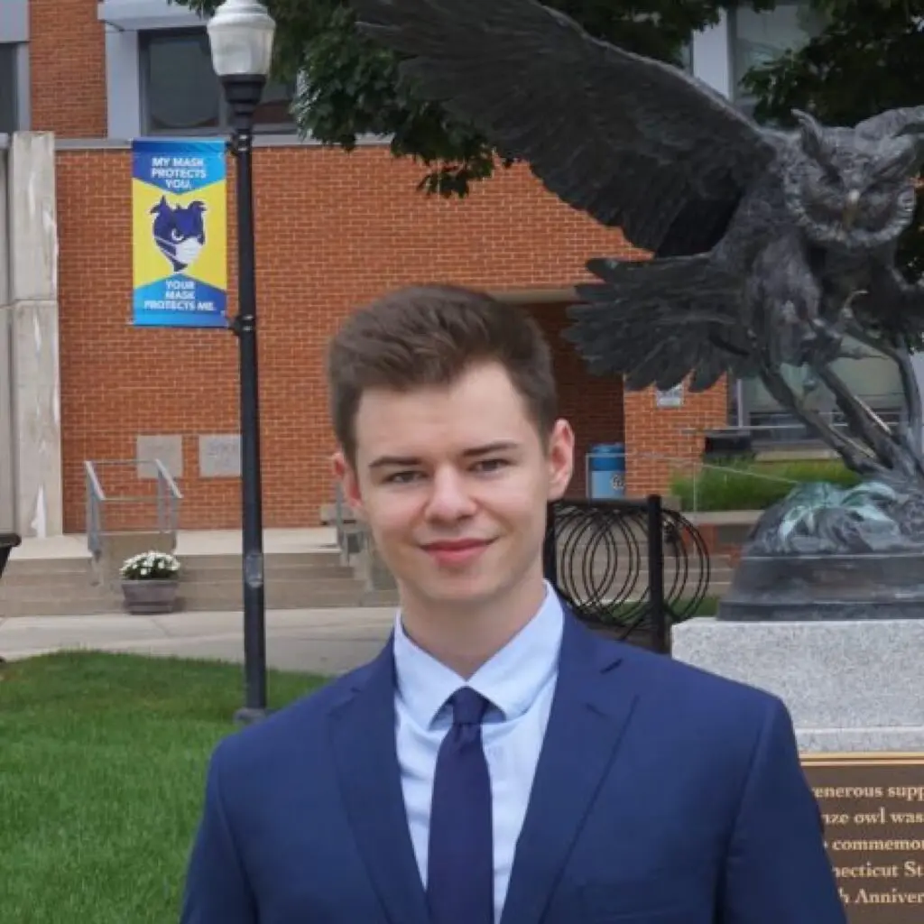 Jonah Gosnay wearing a blue suit and tie with a light blue button-down shirt.