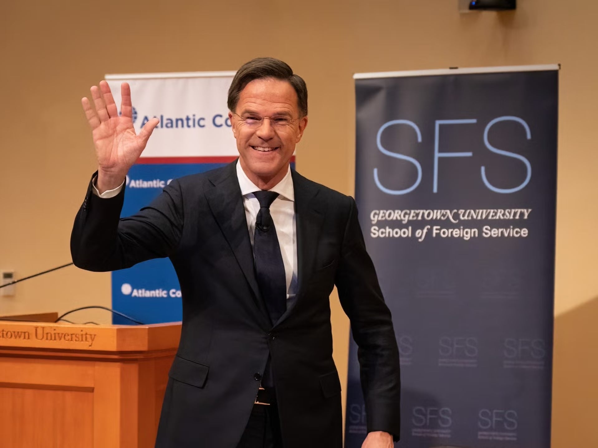 Mark Rutte on stage waving to audience.