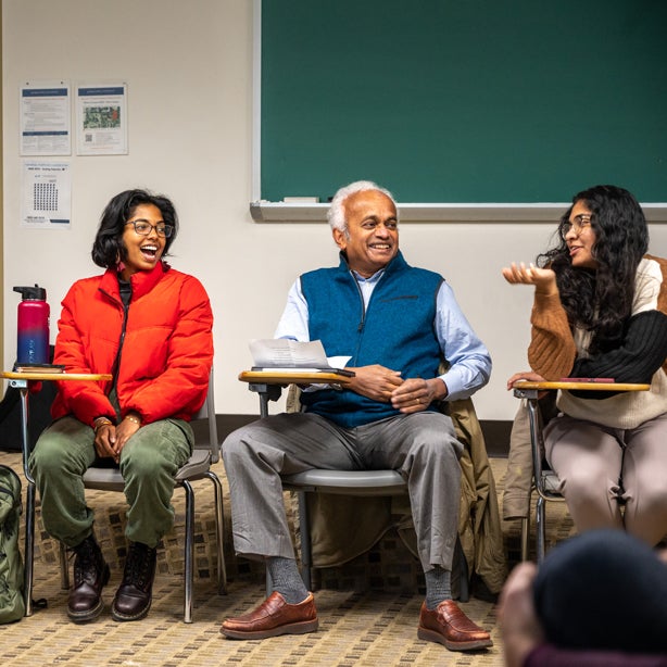 Students engaged in class talking in a circle with professor