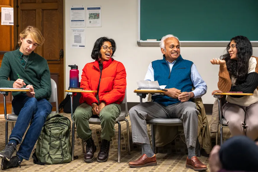 Students engaged in class talking in a circle with professor