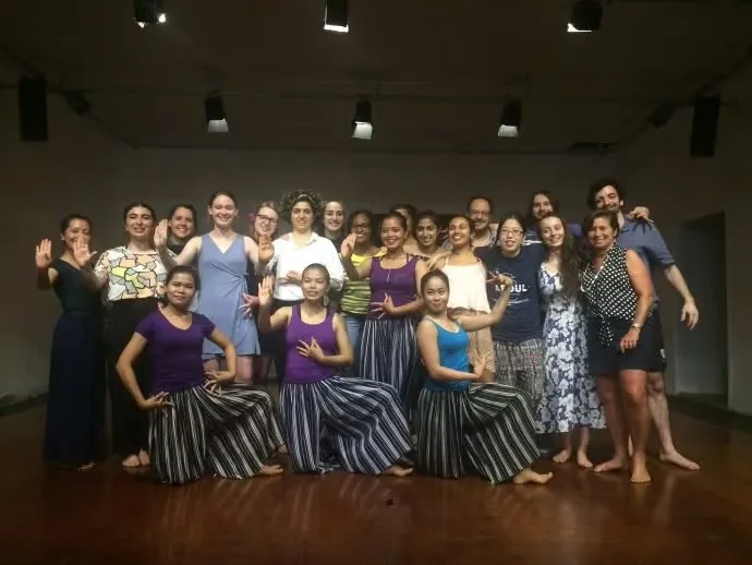 Group of people and performers pose for a photo.