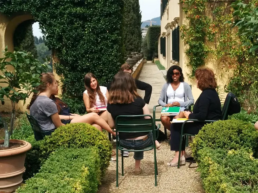 Group of students sitting in a circle in a garden in Europe