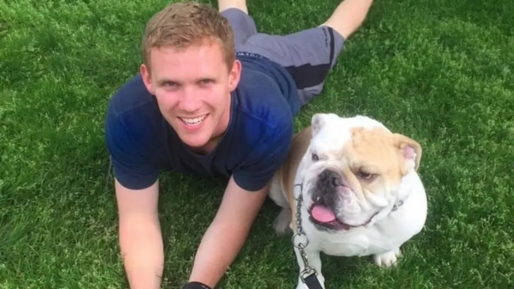 Jack Moore lying on the grass with Jack the Bulldog.