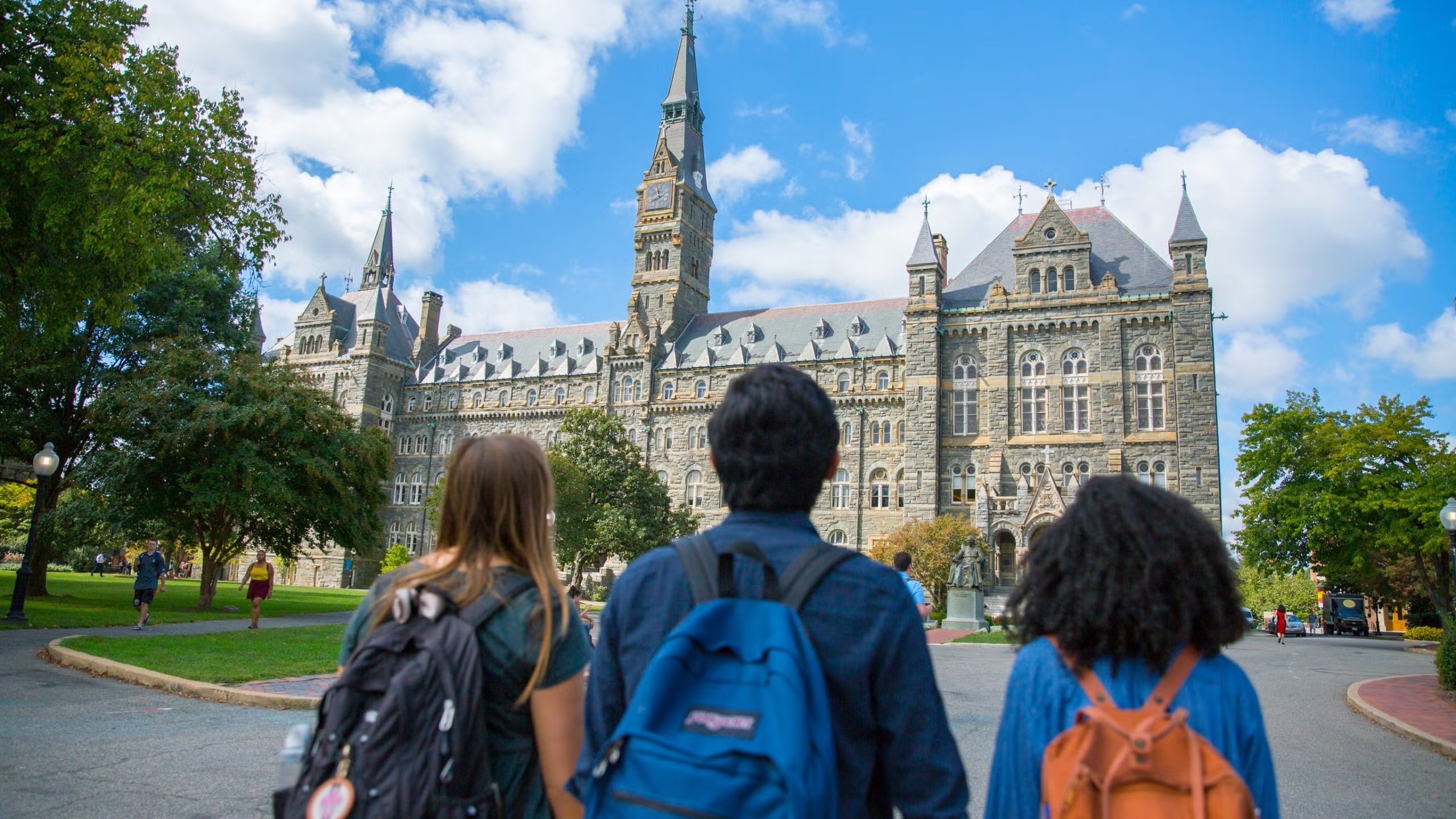 Wide shot of three students looking at Healy Hall.