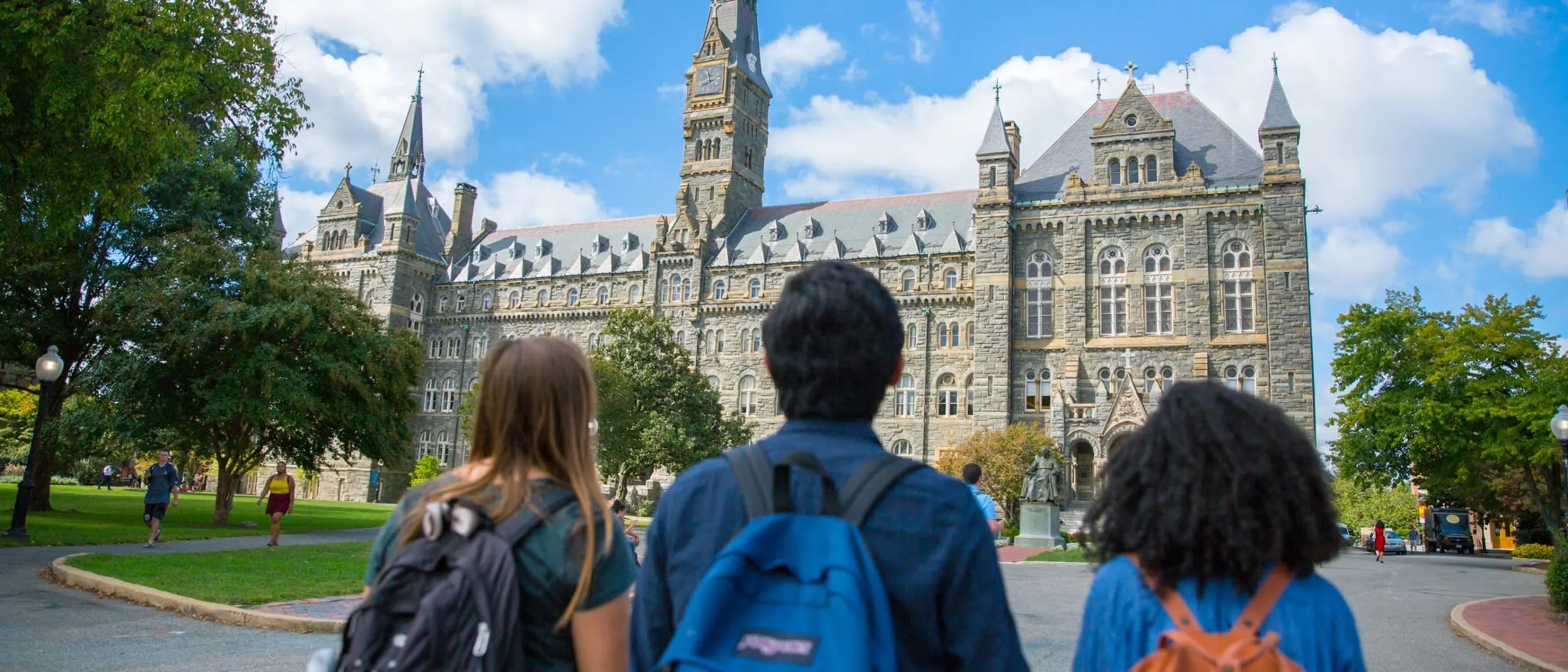 Wide shot of three students looking at Healy Hall.