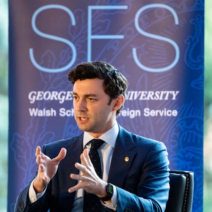 Senator Jon Ossof speaking, in front of a Georgetown University School of Foreign Service banner