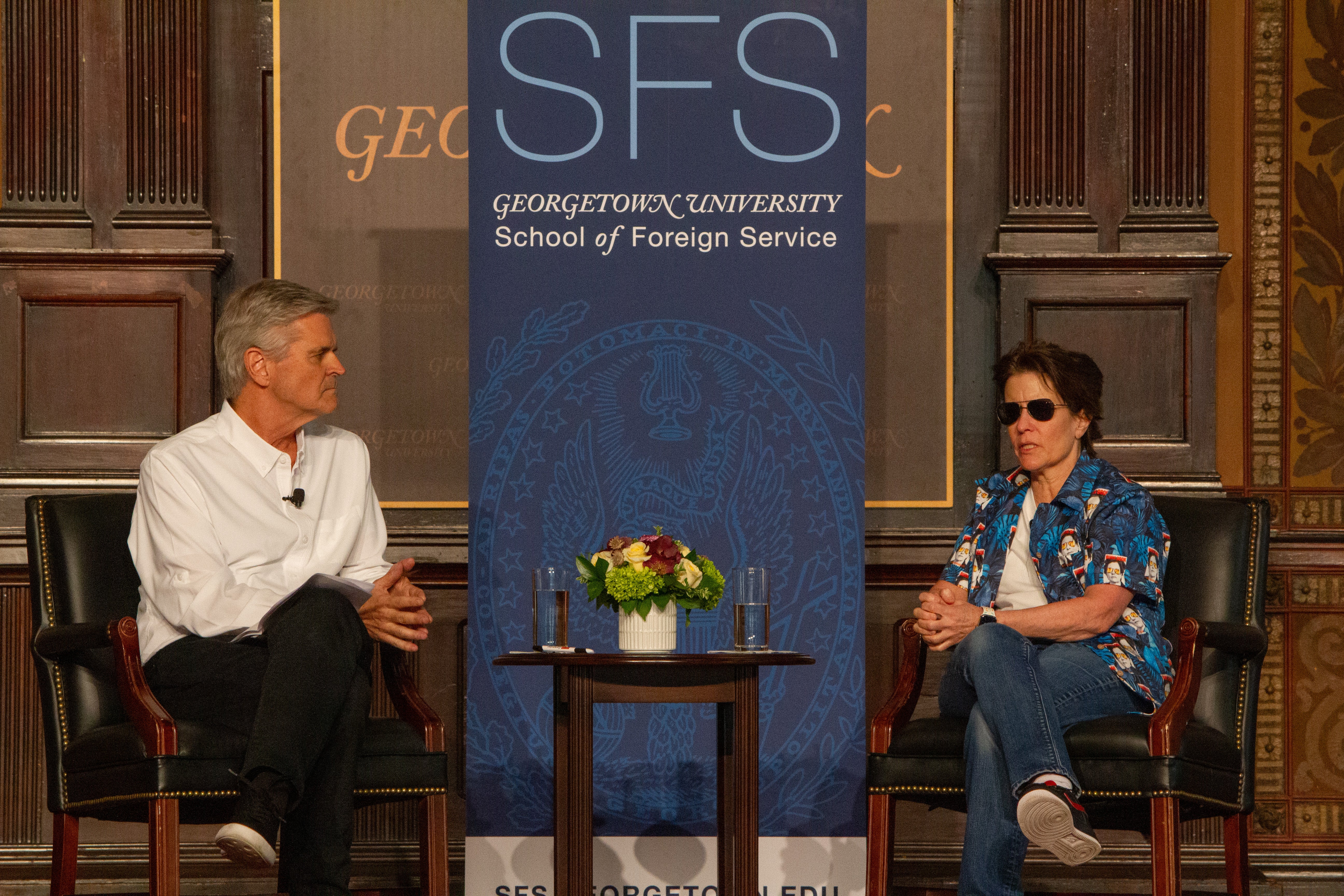 Steve Case and Kara Swisher sit onstage in chairs with an SFS banner behind them in Gaston Hall.