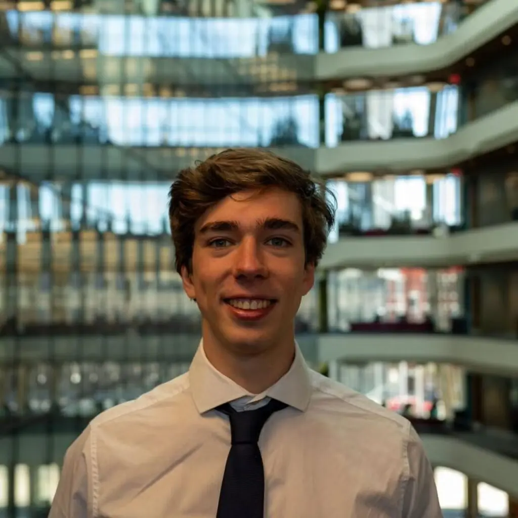 Alessandro Memoli wearing a white button-down shirt and a black tie.