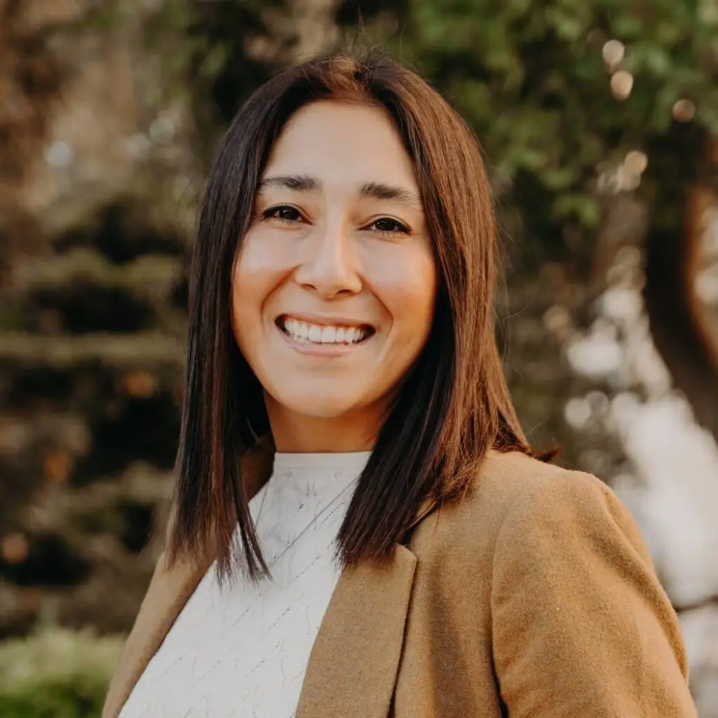 Alexis Lopez wearing a tan blazer and a white blouse.