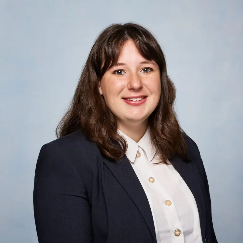 Alyssa Macaluso wearing a dark blazer with white button down shirt.