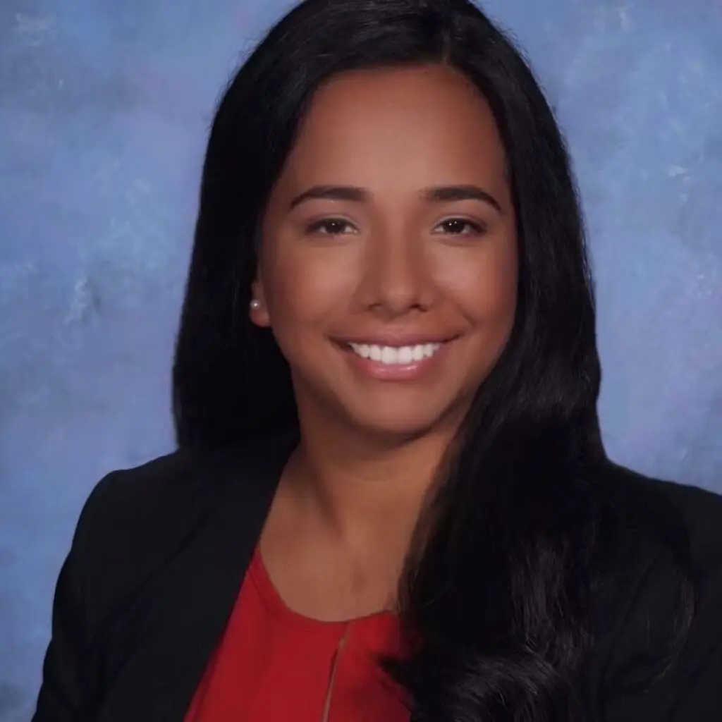 Andrea Quinones wearing a black blazer and red blouse.
