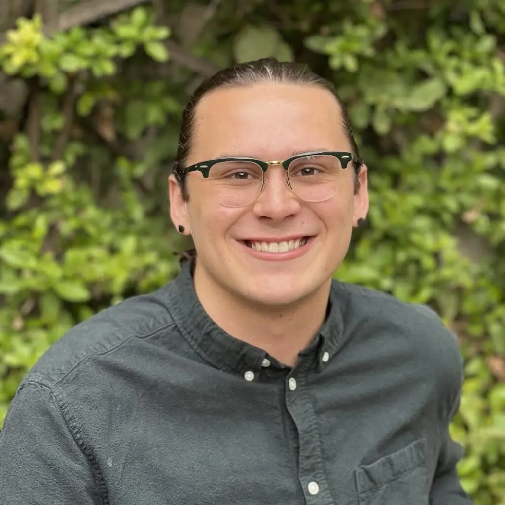 Andrew Hesbacher wearing a grey button-down shirt and glasses.