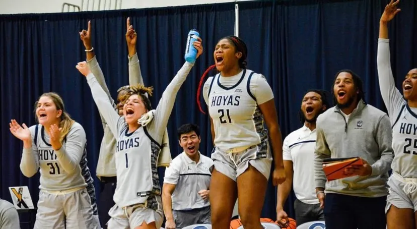 Andrew Park celebrates standing behind students wearing Hoyas uniforms